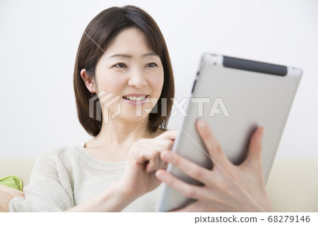 Middle-aged woman looking at tablet PC 68279146