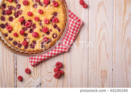 Sweet tasty pie with jellied and fresh raspberry fruits in baking dish with red tablecloth towel 68280266
