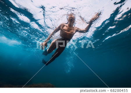 Sporty woman with fins swim in blue sea. Swimming in ocean Sporty woman with fins swim in blue sea. Swimming in ocean 68280455