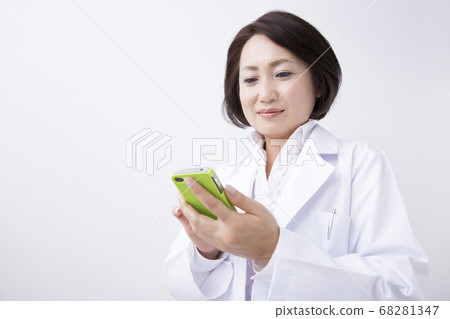 Female doctor looking at a smartphone Female doctor looking at a smartphone 68281347