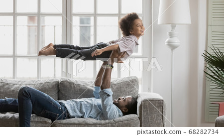 Excited biracial dad and little son playing at home Excited biracial dad and little son playing at home 68282734