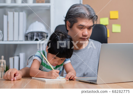 Asian father working at the home office with a Asian father working at the home office with a 68282775
