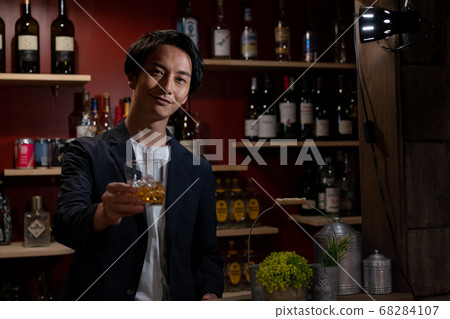 Young bartender serving whiskey 68284107