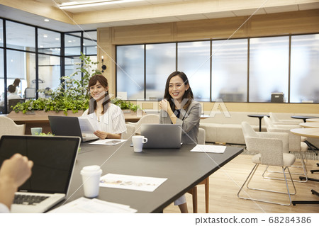 Men and women having a meeting in a casual office Men and women having a meeting in a casual office 68284386