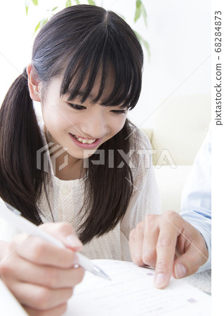 Daughter studying and father teaching 68284873