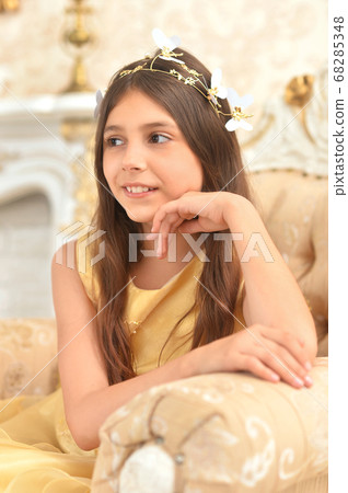 Portrait of girl in yellow dress posing in armchair 68285348
