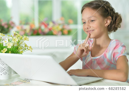 Thoughtful cute girl using laptop at home Thoughtful cute girl using laptop at home 68285582