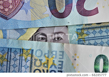 Pile of Euros with eyes peeking out 68285777