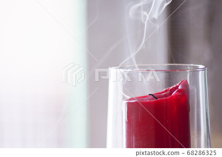 Red candle inside a clear glass vase just blown 68286325