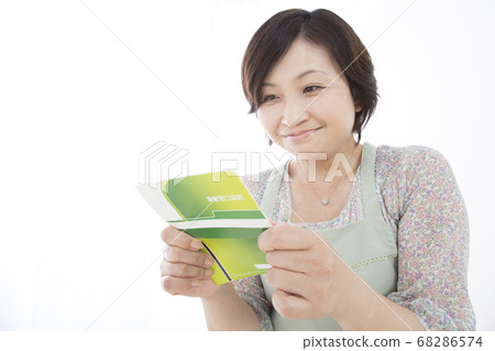 Housewife looking at a bankbook Housewife looking at a bankbook 68286574