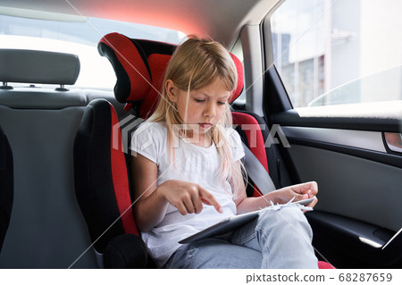 Little cute girl using tablet in car 68287659