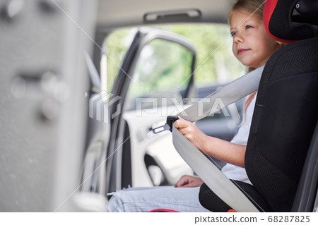 Little girl using safety belt while travelling Little girl using safety belt while travelling 68287825