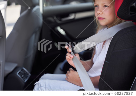 Little girl doing by car in safe seat 68287827