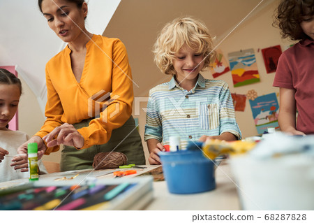 Jolly kids enjoying art lesson with teacher 68287828