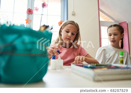 Cute girls communicating during art lesson at school Cute girls communicating during art lesson at school 68287829