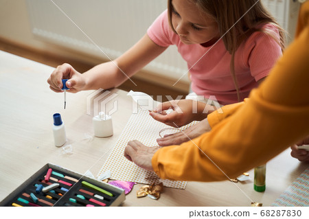 Little girl making handmade application in class room Little girl making handmade application in class room 68287830