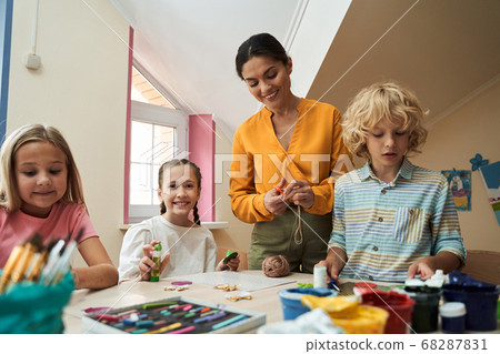 Jolly kids with tutor making handmade crafts 68287831