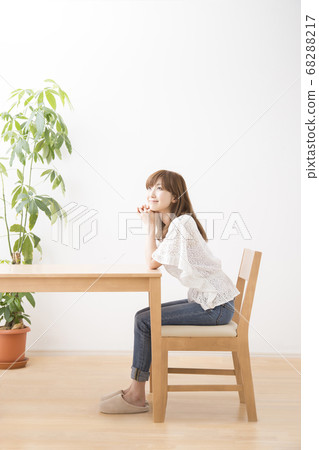 Woman sitting on chair Woman sitting on chair 68288217