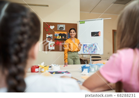 Smiling beautiful woman teaching art for children Smiling beautiful woman teaching art for children 68288231