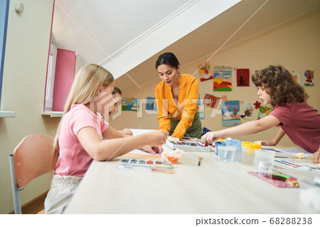 Young pretty woman teaching art at school Young pretty woman teaching art at school 68288238