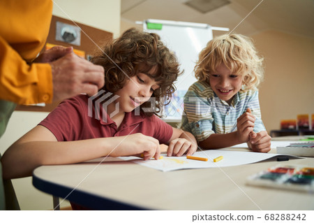 Cute boys drawing with colour pencils at school Cute boys drawing with colour pencils at school 68288242