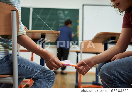 Two naughty boys cheeting during school exam Two naughty boys cheeting during school exam 68288291