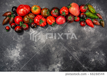 Heirloom tomatoes on dark grey concrete backdrop, Heirloom tomatoes on dark grey concrete backdrop, 68288544