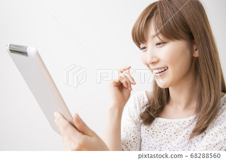 一個女人看著一台平板電腦 68288560