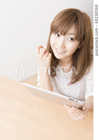 一個女人看著一台平板電腦 一個女人看著一台平板電腦 68288568