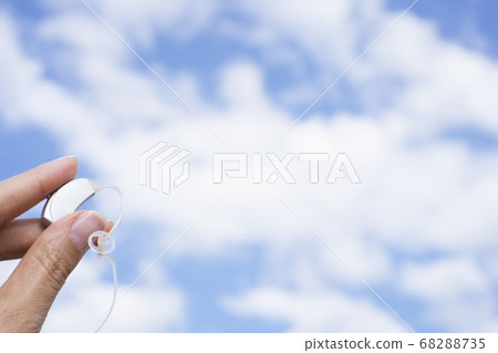 Womans hand holding hearing aid Womans hand holding hearing aid 68288735
