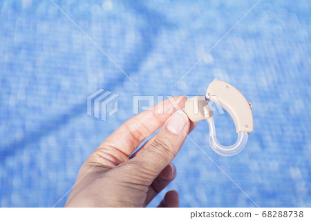 Womans hand holding hearing aid Womans hand holding hearing aid 68288738
