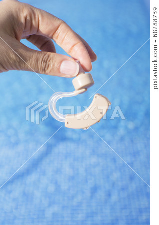 Womans hand holding hearing aid 68288739