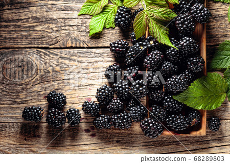 Ripe juicy blackberries with leaves on a wooden Ripe juicy blackberries with leaves on a wooden 68289803