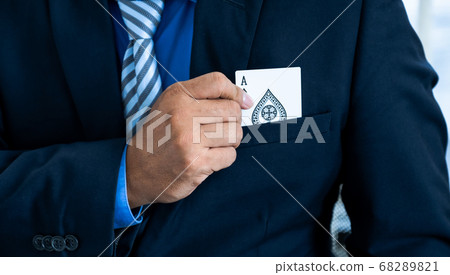 A business man's hand is holding an ace card out of a suit pocket, at a magic poker show or Gambling 68289821