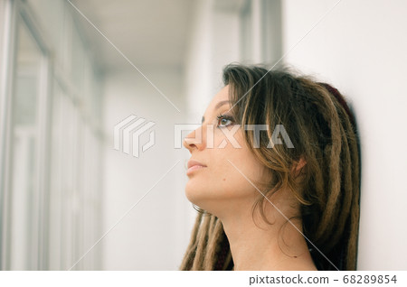 Indoors female portrait of a woman with dreadlocks hairstyle and smoky eyes makeup Indoors female portrait of a woman with dreadlocks hairstyle and smoky eyes makeup 68289854