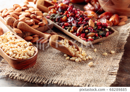 Pine nuts and dried fruits on a old wooden table. 68289885
