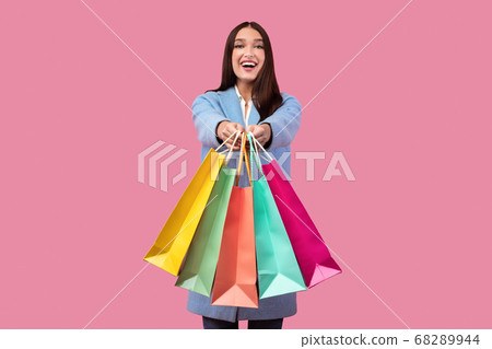 Overjoyed woman showing shopping bags at studio Overjoyed woman showing shopping bags at studio 68289944