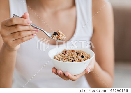 Cropped image of woman holding bowl with homemade granola Cropped image of woman holding bowl with homemade granola 68290186