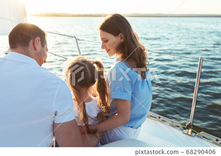Family Enjoying Yacht Tour Sitting On Deck Sailing In Sea Family Enjoying Yacht Tour Sitting On Deck Sailing In Sea 68290406