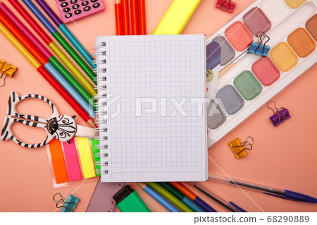 School notebook and various stationery on pink background. Back to school concept. School notebook and various stationery on pink background. Back to school concept. 68290889