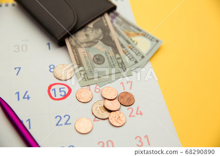 Wallet with money on a calendar on yellow background. Payment day Wallet with money on a calendar on yellow background. Payment day 68290890