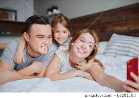 happy smiling family take selfie on bed happy smiling family take selfie on bed 68291108
