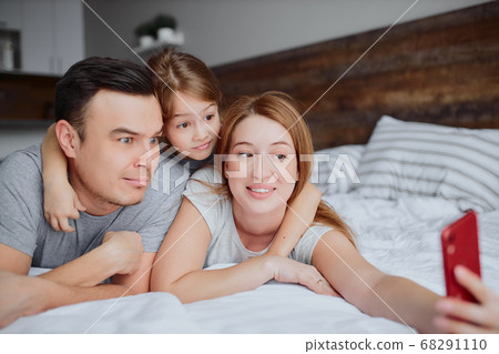 emotional happy family with daughter on bed emotional happy family with daughter on bed 68291110