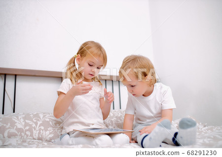 sweet caucasian children use modern gadget, holding tablet in hands 68291230