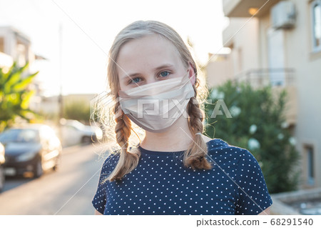 Teen girl in medical protective face mask outdoors 68291540