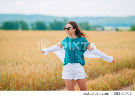 Beautiful girl in wheat field with ripe wheat in hands Beautiful girl in wheat field with ripe wheat in hands 68291761