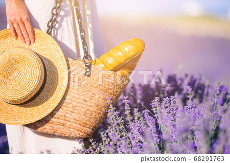 Closeup straw bag and hat in lavender field Closeup straw bag and hat in lavender field 68291763
