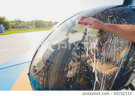 Detail of Helicopter Engineering on a beautiful blue sky,Military Helicopter fighter cockpit. Outdoor wash with sponge and foam. Detail of Helicopter Engineering on a beautiful blue sky,Military Helicopter fighter cockpit. Outdoor wash with sponge and foam. 68292337