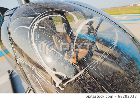 Detail of Helicopter Engineering on a beautiful blue sky,Military Helicopter fighter cockpit. Outdoor wash with sponge and foam. Detail of Helicopter Engineering on a beautiful blue sky,Military Helicopter fighter cockpit. Outdoor wash with sponge and foam. 68292338