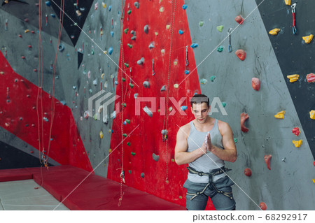 Tired climber having a rest after climbing bouldering wall 68292917